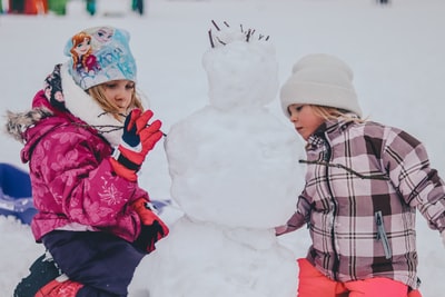 两个女孩在白天堆雪人